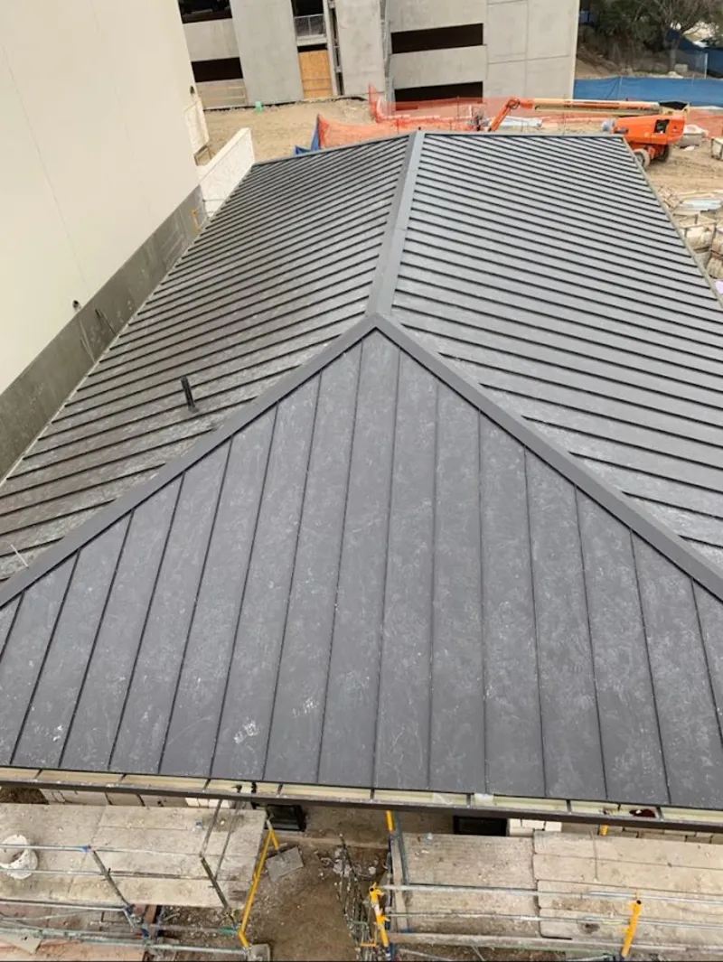 Commercial metal roof construction with crane equipment in Farmingdale